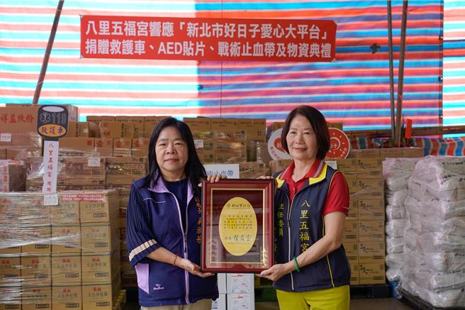 八里五福宫捐赠3千斤白米及824箱物资给新北市弱势家户，由主委郑戴丽香（右）代表捐赠、社会局副局长吴淑芳代表受赠。（张铠乙摄）