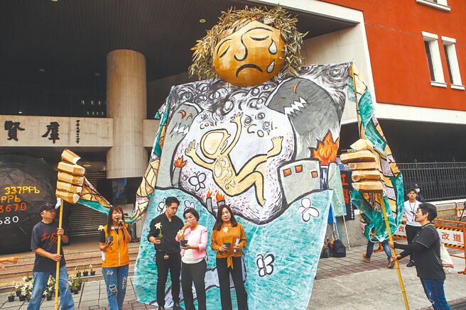 逾30个环保团体22日集结在立法院前，并立起3公尺高的大型黑色球体及「竹山妈大偶」，呼吁跨党派立委提案支持2028年前「无煤中火」。（邓博仁摄）