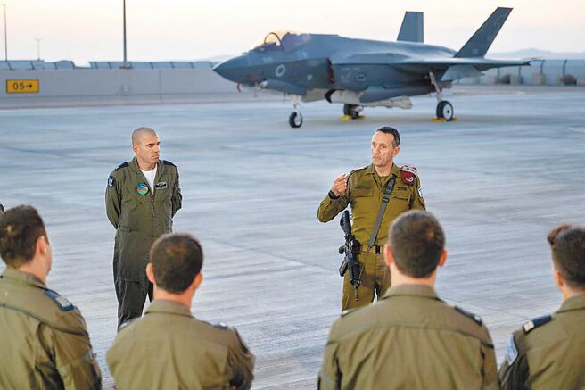 以色列国防军总参谋长哈勒维（右）15日在空军基地表示，伊朗发动的飞弹和无人机袭击史无前例，将遭到回应。（新华社）
