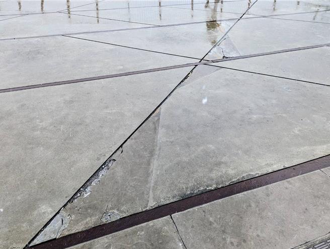 基隆市忠一路通往海洋广场的路段有高低落差，容易造成身障人士行经时跌倒受伤。议员韩世昱痛批该处工程还没验收，就已经出现路面破损。（张志康摄）