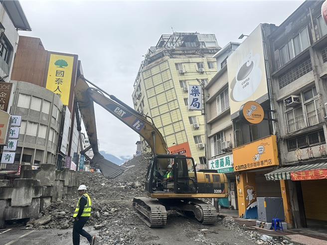 花莲市区富凯大饭店昨凌晨因地震倾斜成危楼，县府正进行8米高填土作业，稳固建物基础，预计今晚8时开始试拆。（罗亦晽摄）