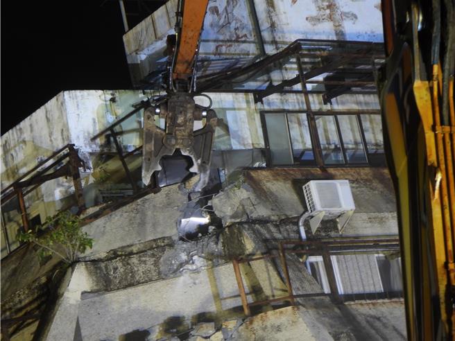 花莲市富凯大饭店昨因密集地震倾斜倒塌，工程单位今天傍晚完成8米填土工作，稳定建物基础，全国最长长达42米的大割机「鲁夫号」晚间8时45分正式开拆，力拚2周拆完。（罗亦晽摄）