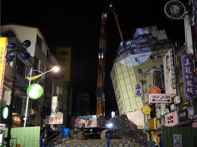 花莲市富凯大饭店昨因密集地震倾斜倒塌，工程单位今天傍晚完成8米填土工作，稳定建物基础，全国最长长达42米的大割机「鲁夫号」晚间8时45分正式开拆，力拚2周拆完。（罗亦晽摄）