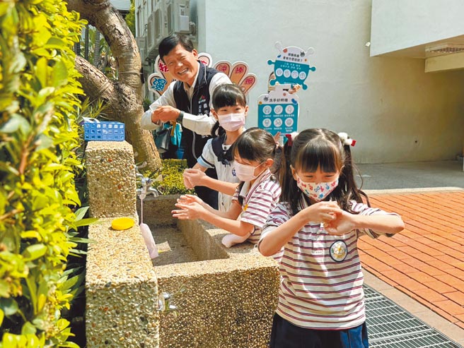 肠病毒提早进入流行期，台中市卫生局携手麦当劳叔叔之家慈善基金会，22日上午于中教大附设实验小学宣导正确洗手观念；卫生局长曾梓展（后）与小朋友示范正确洗手步骤。（潘虹恩摄）