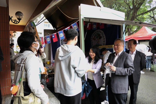 中美洲經貿辦事處主任徐韶慧(中)與醒吾科大旅運系主任黃明一，一起發美食給排隊學生。(照片/醒吾科技大學提供)