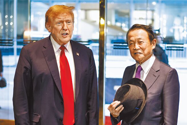 美国前总统川普（左）23日于纽约会见日本前首相麻生太郎（右）。（美联社）