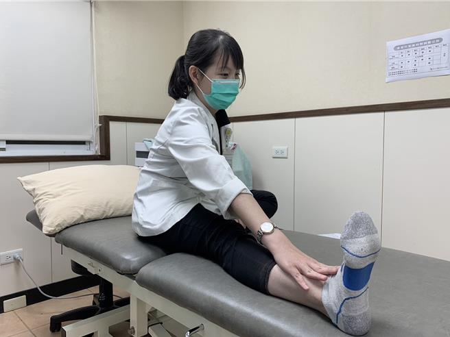 第三式「伸展小腿」，坐姿，一条腿伸直在身前，另一条腿向一侧弯曲。身体前倾，同时保持腿和背部尽量伸直，停留15至20秒。1组10下，伸展放松小腿。（高市活力得中山脊椎外科医院提供／杨舒婷高雄传真）