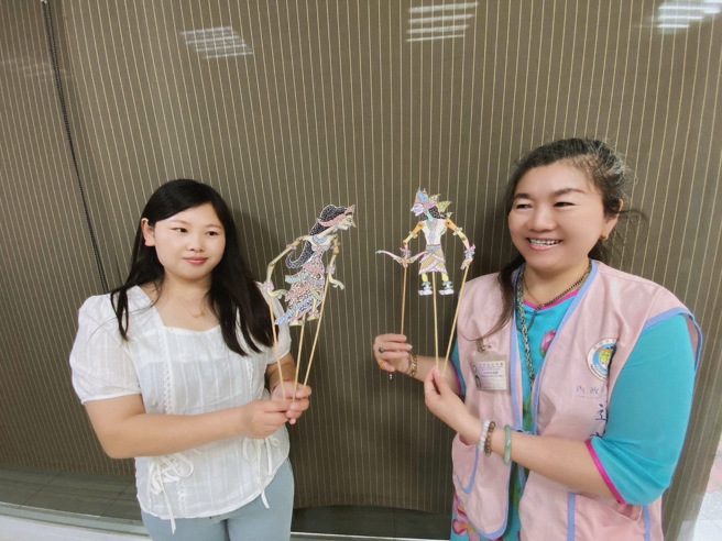 大陆新住民艷红(左)和越南语通译青竹(右)一起操作皮影人偶。(移民署嘉义市服务站提供)