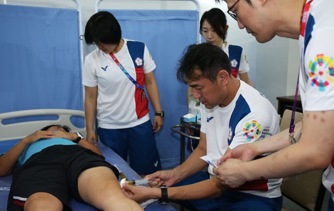 中华队队医林瀛洲在2018雅加达巨港亚运为选手治疗。（林瀛洲提供）