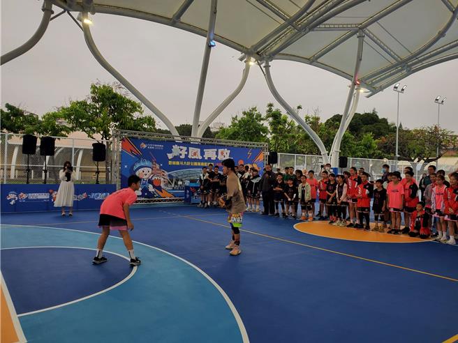 启用典礼中花式街头篮球好手「小夫」展露花式篮球功夫，并与一名小学生斗牛。（周丽兰摄）