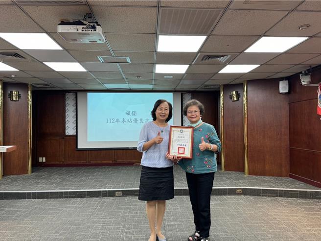 移民署臺北市服務站主任蘇慧雯(左)頒發優良志工獎狀予林雪英(右)，服務精神為志工團典範。（移民署提供）