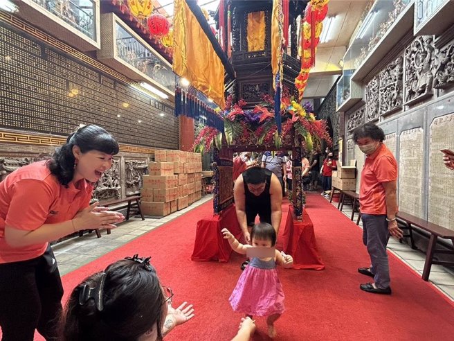 农历3月疯妈祖，屏东慈凤宫28日举办行之有年的「定点钻轿脚」，吸引眾多信徒抢钻，庙方还因应食安风暴为每位钻轿脚的信眾送上一双筷子，象徵「一筷平安」，为大家祈福消灾。（谢佳潾摄）