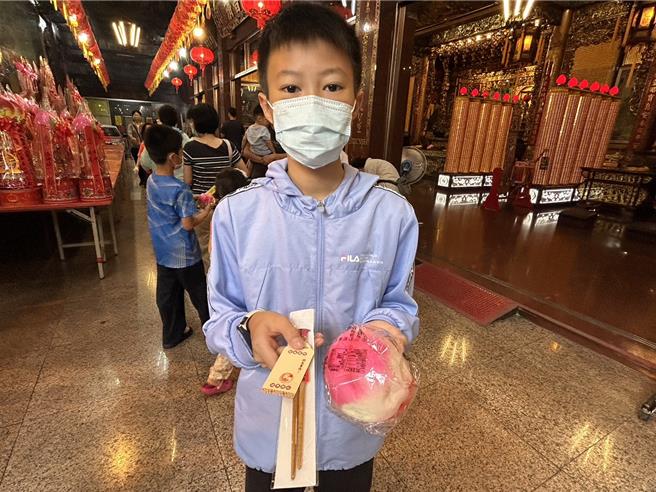 农历3月疯妈祖，屏东慈凤宫28日举办行之有年的「定点钻轿脚」，吸引眾多信徒抢钻，庙方还因应食安风暴为每位钻轿脚的信眾送上一双筷子，象徵「一筷平安」，为大家祈福消灾。（谢佳潾摄）