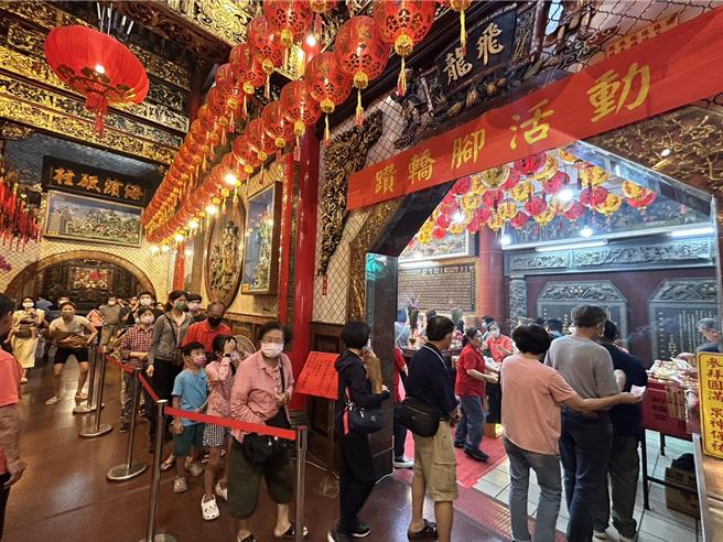 农历3月疯妈祖，屏东慈凤宫28日举办行之有年的「定点钻轿脚」，吸引眾多信徒抢钻，庙方还因应食安风暴为每位钻轿脚的信眾送上一双筷子，象徵「一筷平安」，为大家祈福消灾。（谢佳潾摄）