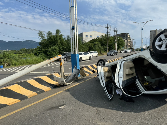白色轎車駕駛精神不濟，自撞中央分隔島，號誌桿被撞斷。（翻攝畫面）