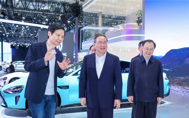 大陸總理李強（中）昨天視察北京國際車展，李強表示，要大力發展智慧網聯新能源汽車。左為小米創始人雷軍。（新華社）