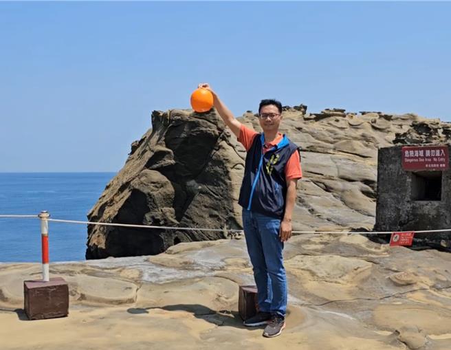 新北市瑞芳区象鼻岩日前因自然风化下断裂，但民眾发现断裂后的象鼻岩变成可爱水豚君，瑞芳区所放上道具橘子提供民眾拍摄，由区长杨胜闵亲自示范。（图／翻摄画面）