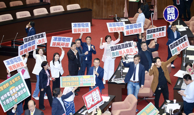 立法院30日院會處理凍漲電價案，國民黨立委高舉標語，並以人數優勢，在表決中否決民進黨提案，並通過凍漲案。（姚志平攝）