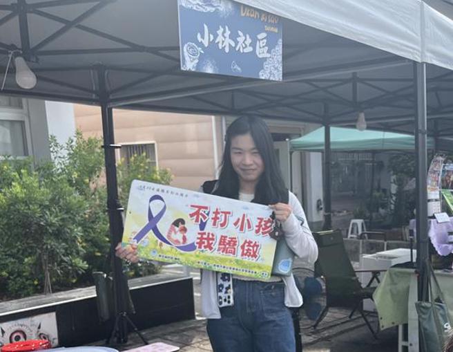 高雄1名妈妈主动拿起「不打小孩　我骄傲」的告示牌，向儿子当场宣誓不打小孩，儿子当场拍照存证，2人约定，当妈妈要打小孩子，就把宣誓照片亮出来。（林雅惠摄）