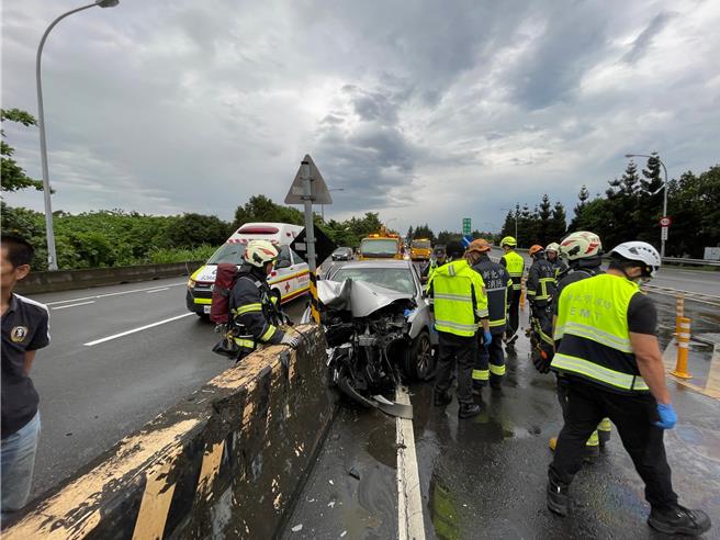 疑因天雨路滑，轎車失控自撞護欄。（新北市消防局提供）