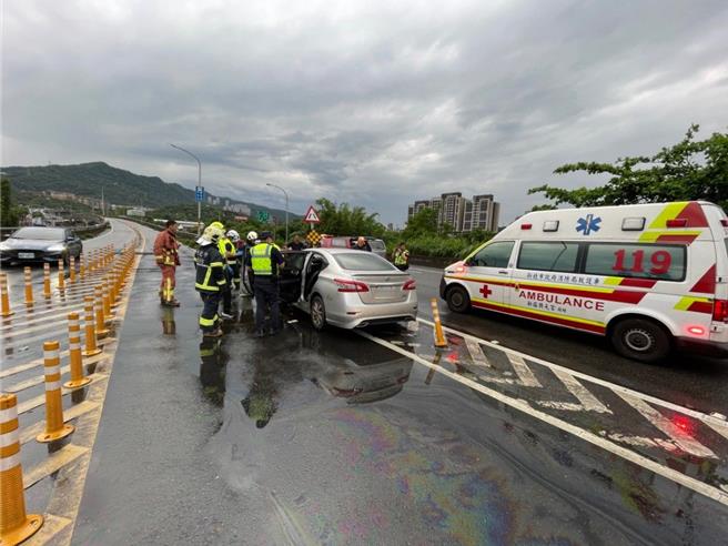 轎車失控自撞護欄，2人受困車內，警消緊急救出2人，並送往醫院急救。（新北市消防局提供）