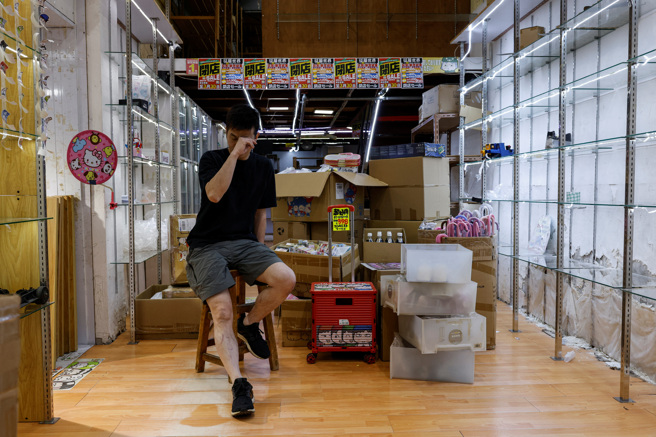 在香港旺角經營日本禮品店的余先生停止實體營運，收拾店內商品時難掩落寞之情。（路透）