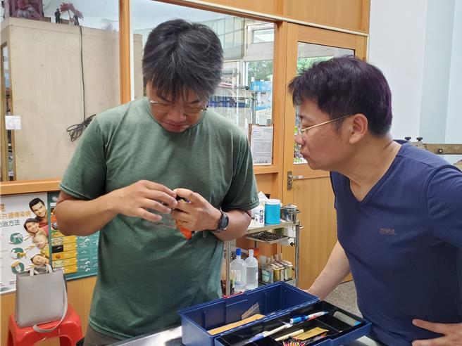 云林鸟会繫放志工陈嘉宏（左）与斗六市新生动物医院兽医师陈金发（右），为蓝翅八色鸫检查无碍后，为牠繫上脚环做纪录。（周丽兰摄）