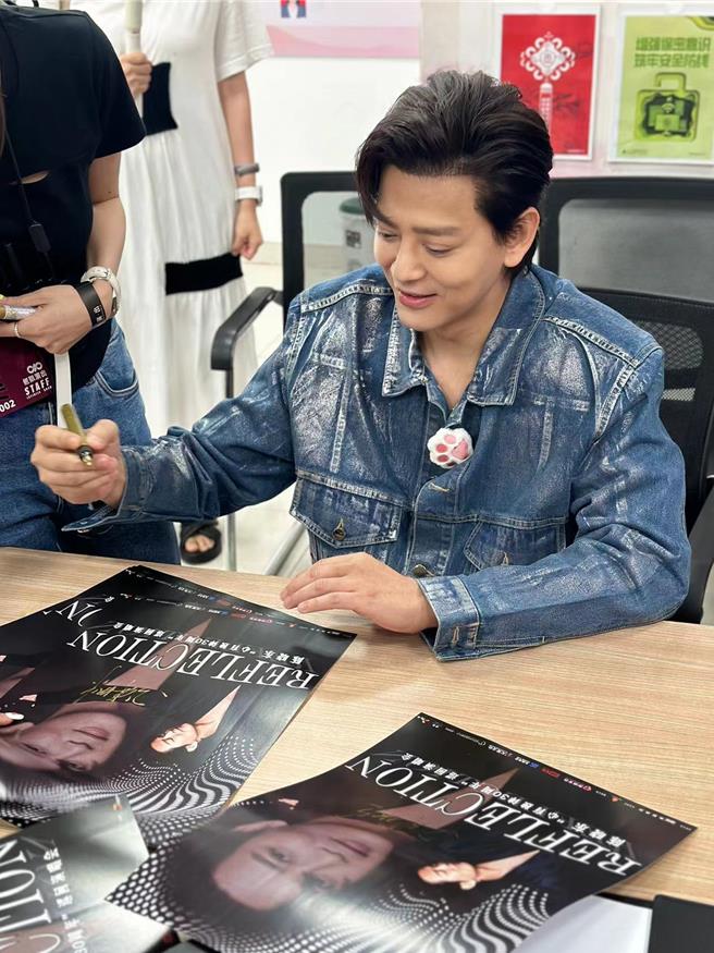 陈晓东在现场特别签署主办单位准备的演唱会黑、白两款海报送给歌迷。（火爆娱乐提供）