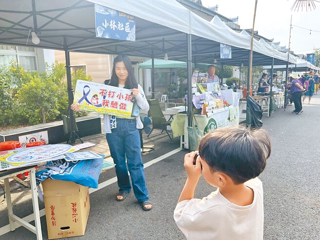 高雄1名媽媽主動拿起「不打小孩我驕傲」的標語，向兒子承諾不體罰，兒子當場拍照存證。（林雅惠攝）