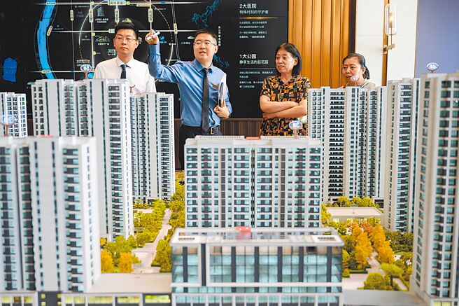 北京市、天津市住建委4月30日各自宣布放寬房市限購新政。圖為大陸銷售人員為民眾介紹房型。（中新社）