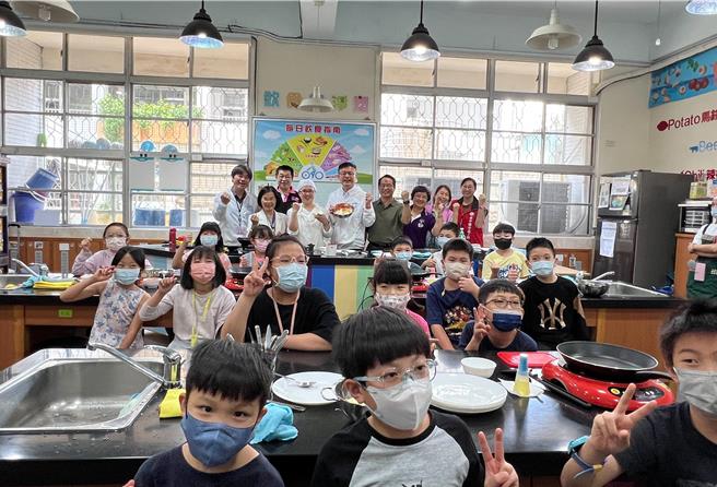 教育局长张明文与小朋友互动制作高丽菜煎饼。（高钧麟摄）