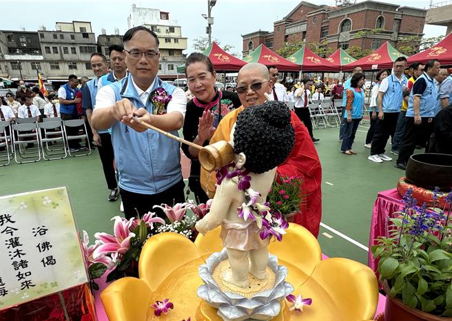 金门县副县长李文良(左一)也与现场民眾随喜浴佛，希望藉此为大眾开启自性光明之光，洗涤烦恼带来的困苦。(于家麒摄)
