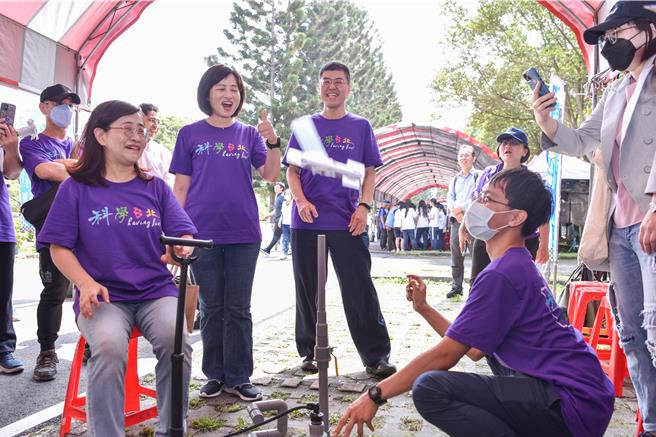 台北市副市长林奕华(左1)体验体验台师大物理系旋转空气炮摊位。(台师大提供)