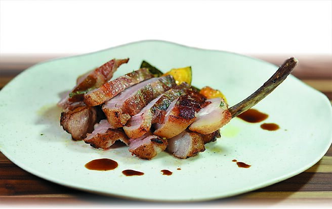 〈跳进嘴里〉是〈炭烤噶玛兰黑豚战斧〉，主厨以鼠尾草和义大利生火腿包覆在猪肉外层，先煎后烤至七分熟上桌。图／姚舜