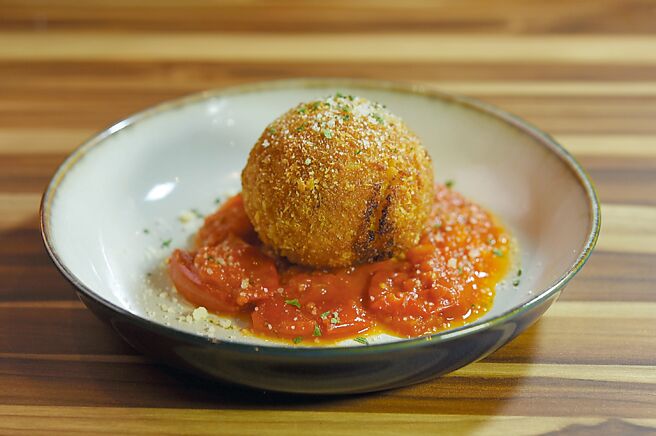 〈和牛炸饭糰〉是将西西里岛街头美食〈炸饭糰〉（Arancini）华丽升级，将陈年义大利米做的饭糰，以用牛骨髓与红酒调味的和牛腿绞肉及马兹瑞拉起司为内馅，风味与口感皆诱人。图／姚舜