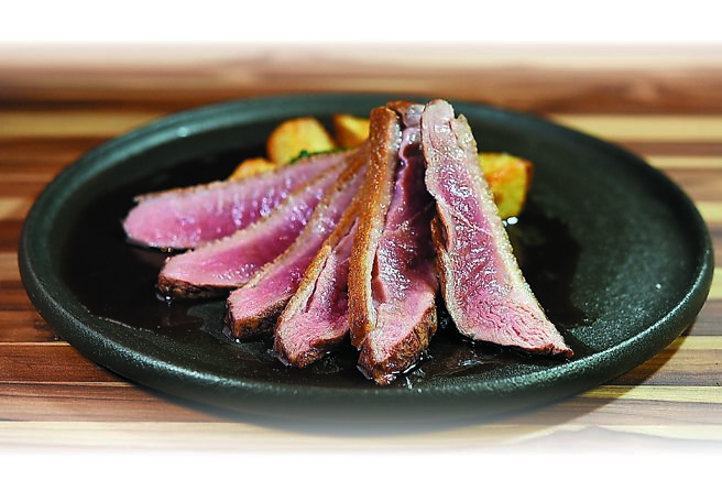 〈烤玫瑰鸭胸〉选用彰化芳苑玫瑰鸭熟成三至五天后，先将表皮煎至酥香脆后再炉烤，鸭肉肉质粉嫩、口感柔嫩，并用融合鸡汁、鸭汁、橙汁及波特酒添香的酱汁提味。 图／姚舜