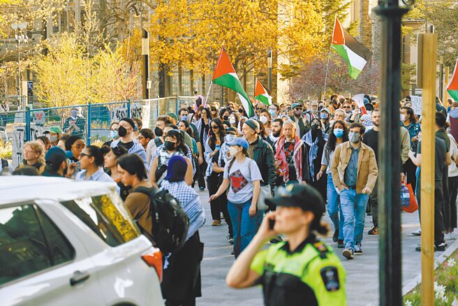 反战学生2日在加拿大多伦多大学的草坪上搭帐篷，并在周围游行示威。（中新社）