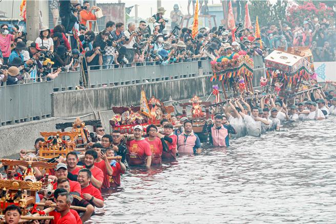 嘉义县布袋镇新塭嘉应庙5日举办一年一度「衝水路、迎客王」祭典，适逢假日，今年参与盛事民眾更多，王船码头挤得水泄不通。（吕妍庭摄）