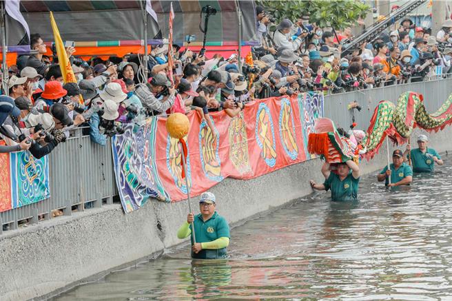 在眾人吆喝声中，神轿陆续下水，遶行水域迎无形客王上岸做客。（吕妍庭摄）