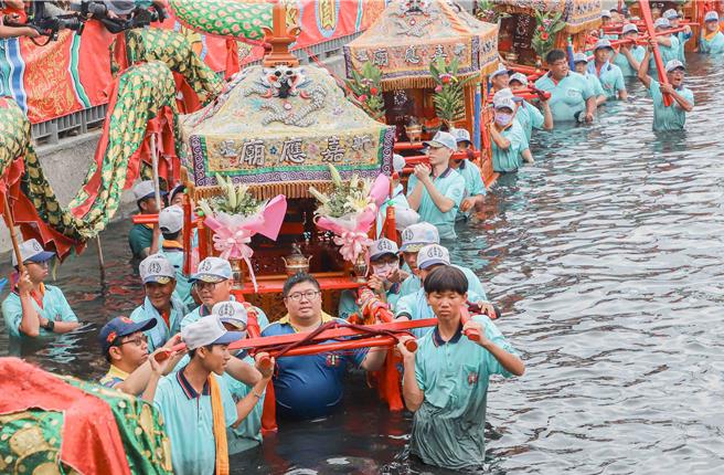 立委蔡易余也不畏溼身，扛轿遶行水域迎无形客王上岸做客，现场气氛热闹滚滚。（吕妍庭摄）