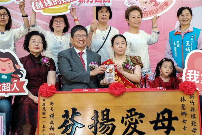 新竹縣113年模範母親表揚大會，來自印尼的43歲林慧娜（右二），是最年輕且唯一的新住民模範母親，縣長楊文科（左二）頒贈「母愛揚芬」匾額及母親節禮物。（羅浚濱攝）