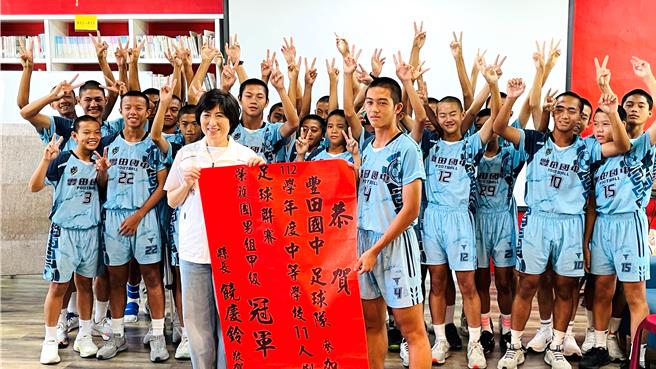 台东县长饶庆铃（左）颁赠红榜，恭贺丰田国中男子足球队勇夺队史第4座全国冠军。（萧嘉蕙摄）