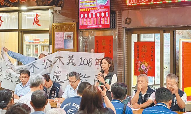 台北市关渡平原附近大度路南侧公共设施保留地，30年来未提出具体开发计画却也不解编、不徵收，市议员黄瀞莹（后右三）7日开协调会，当地居民、地主拉布条抗议市府不作为。（丁上程摄）