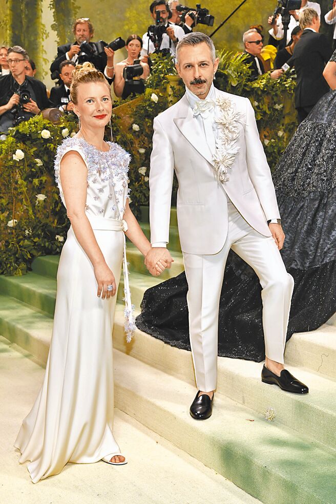男星傑瑞米史壯（右）以一身奶油白的Loro Piana西裝現身，領片上的白色玫瑰花意外為這套服裝增色不少。（美聯社）