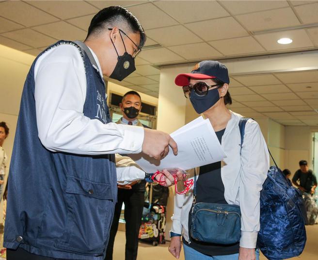 李陈妙音是泰国蓝海公司负责人，自2016年至2018年间非法吸取资金逾6亿元泰铢，涉嫌违反银行法。调查局与泰国执法机关合作协缉，于5月9日下午自泰国曼谷将外逃通缉犯李陈妙音追缉返台，调查局人员在李陈妙音下机后，在登机门口向她宣读权利义务后上铐。（陈麒全摄）