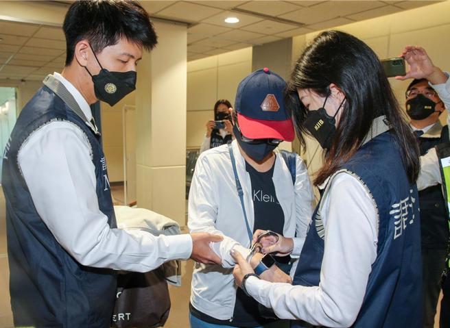 李陈妙音是泰国蓝海公司负责人，自2016年至2018年间非法吸取资金逾6亿元泰铢，涉嫌违反银行法。调查局与泰国执法机关合作协缉，于5月9日下午自泰国曼谷将外逃通缉犯李陈妙音追缉返台，调查局人员在李陈妙音下机后，在登机门口向她宣读权利义务后上铐。（陈麒全摄）