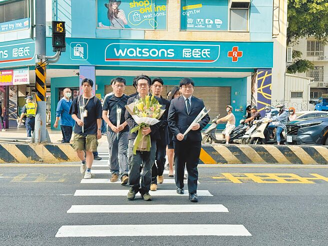 行人零死亡推動聯盟10餘人，8日手持白花重回余小妹車禍現場的路口，悼念她來不及長大的生命。（曹婷婷攝）