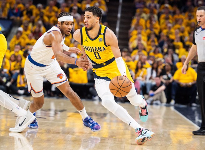 哈利伯頓(右)運球突破阿丘瓦防守。(路透)