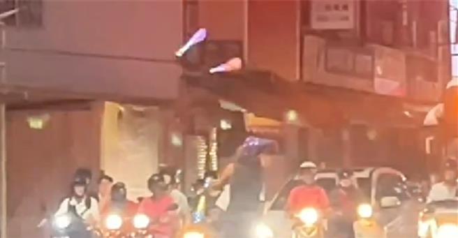 男子頭戴慶生帽在路口斑馬線上表演雜耍戲碼。（翻攝照片／楊舒婷高雄傳真）