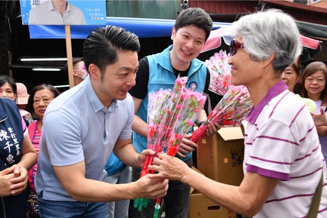 适逢母亲节前夕，台北市长蒋万安（左）应国民党台北市议员李柏毅（中）之邀，一早前往景美市场发放康乃馨。（台北市政府提供／丁上程台北传真）